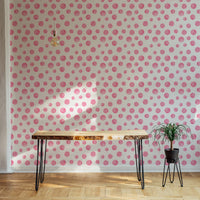 Abstract circles wallpaper on a feature wall with a wooden console and green plant.