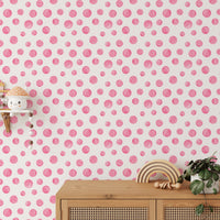 Watercolor circles wallpaper behind a wooden sideboard in kids room.