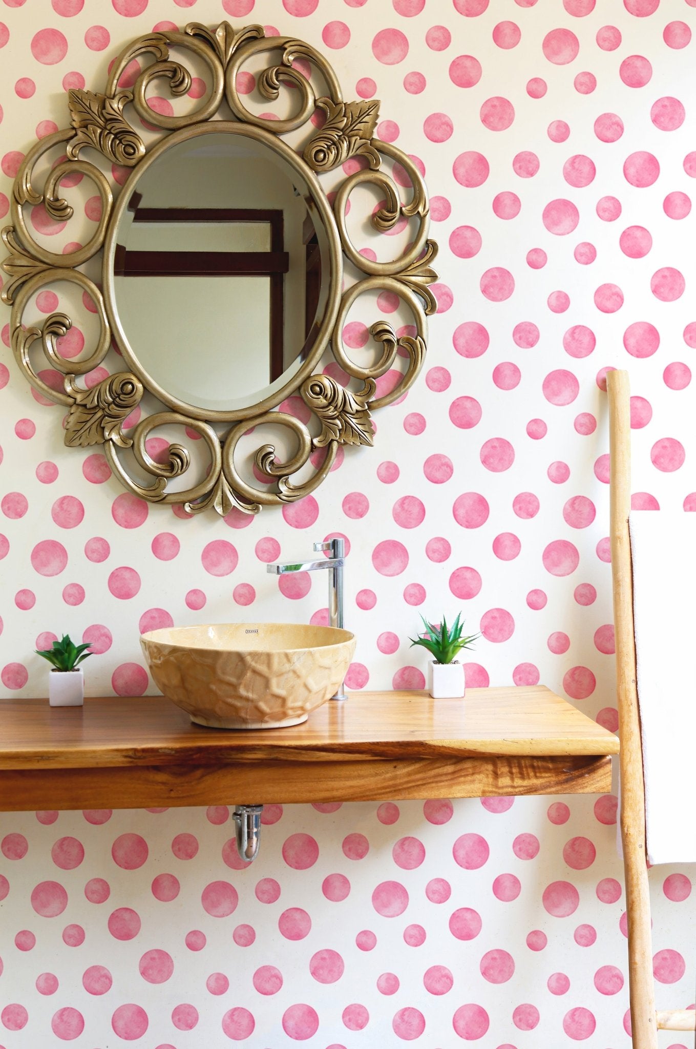 Polka Dots Pink Watercolor Abstract Circles Wallpaper in a bathroom with a gold mirror.