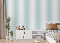 Bedroom wall featuring turquoise vertical stripe wallpaper next to a white cabinet.