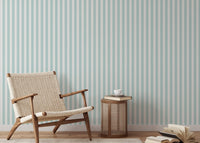 Preppy vertical stripe wallpaper in a reading area with a woven chair.