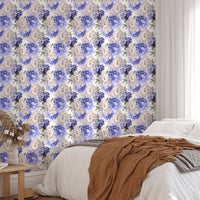 Purple peonies flower wallpaper in a bedroom with a brown throw blanket.