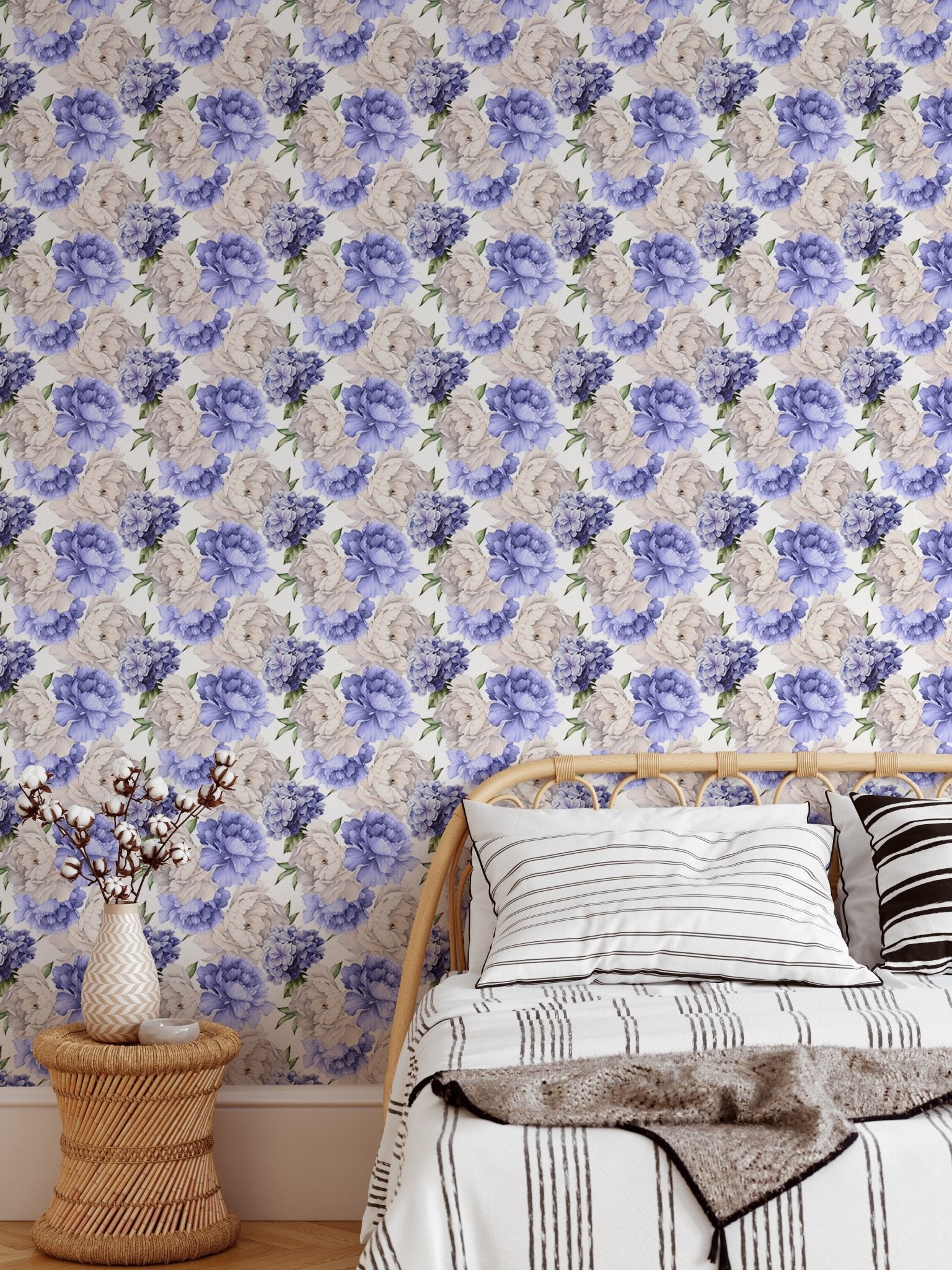 Flower wallpaper behind a single bed with neutral-toned pillows.