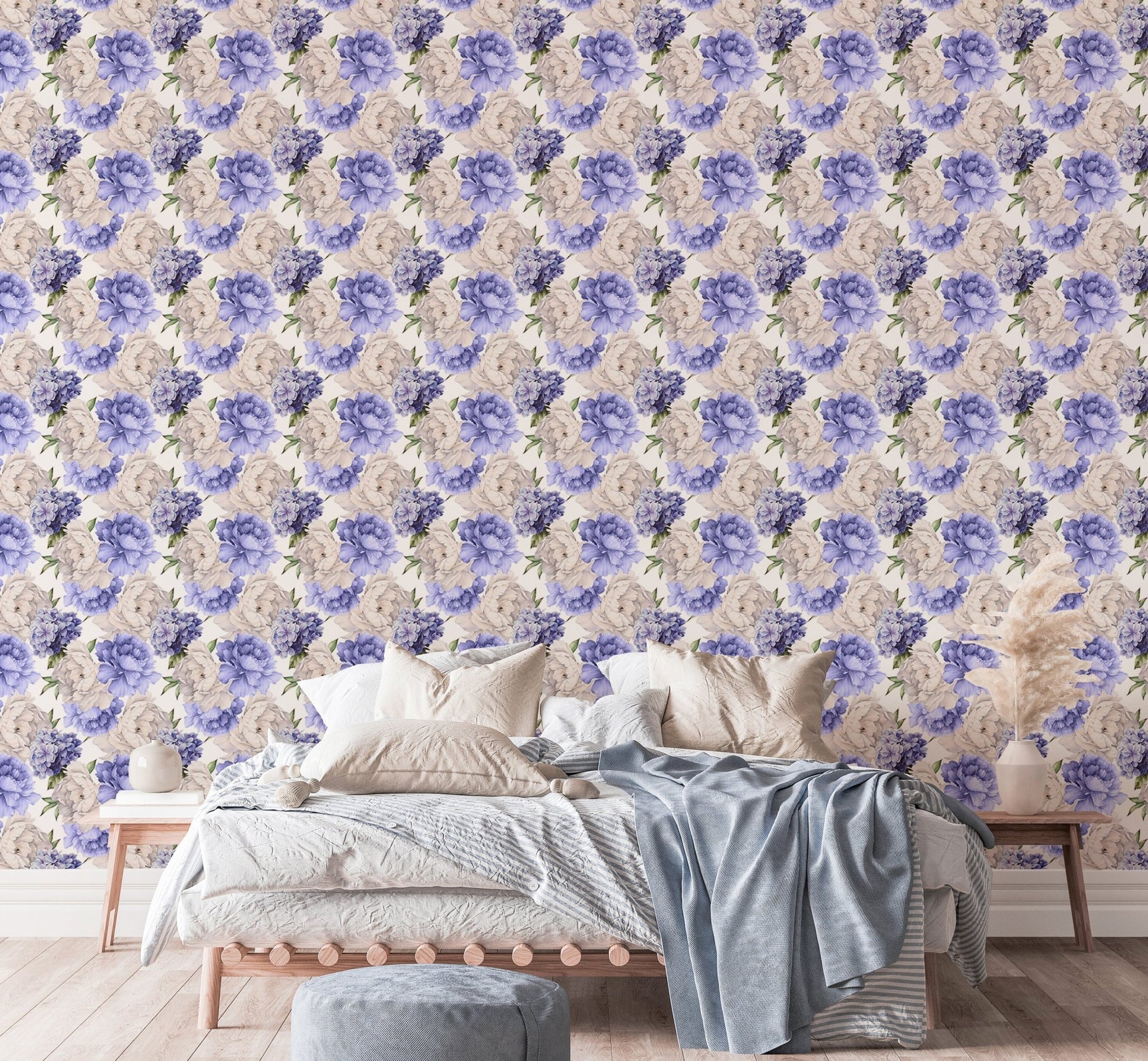 Large bed with light linens against a purple watercolor floral wallpaper.