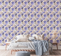 Large bed with light linens against a purple watercolor floral wallpaper.