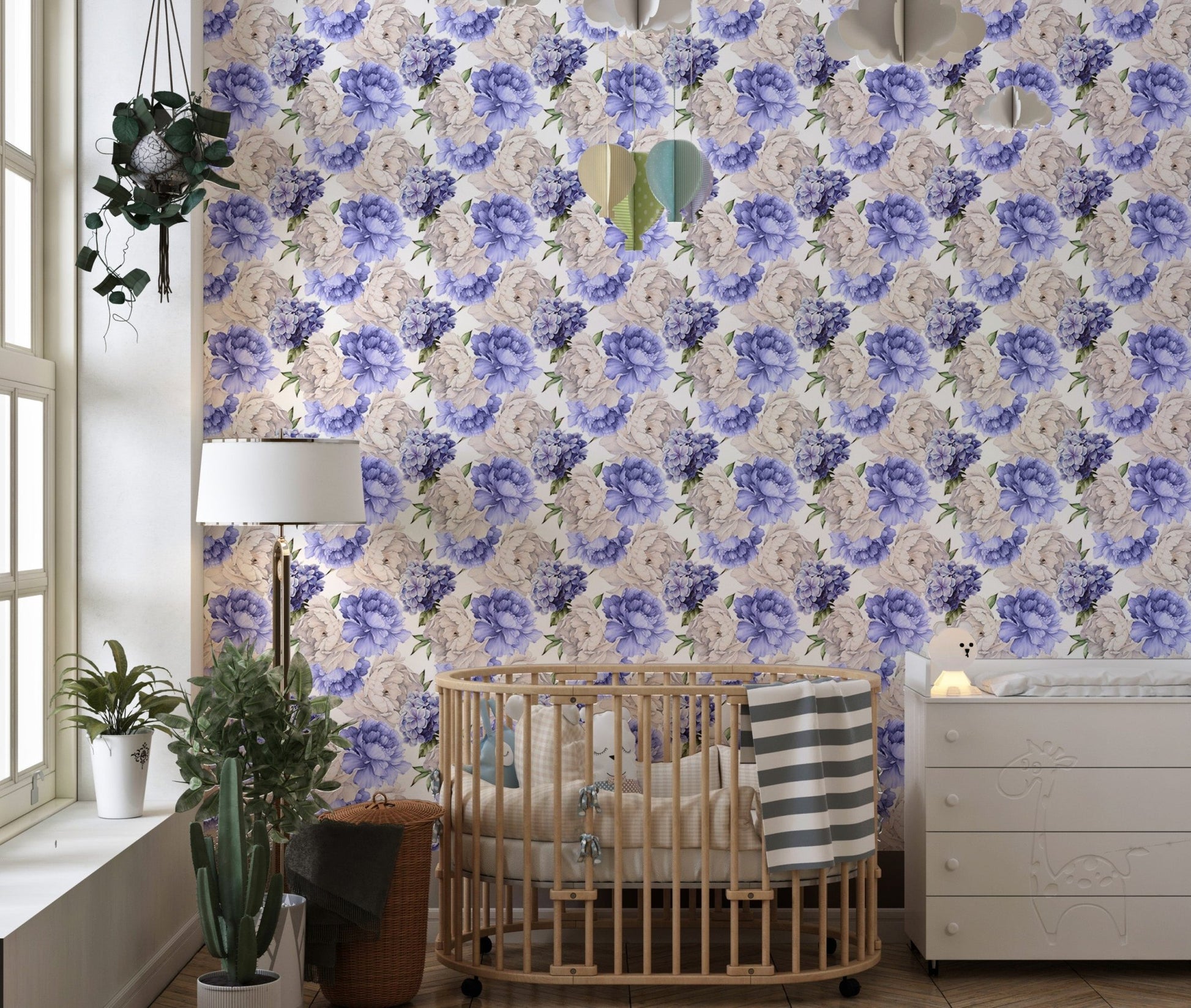 Light background floral wallpaper behind a wooden crib in a nursery room.