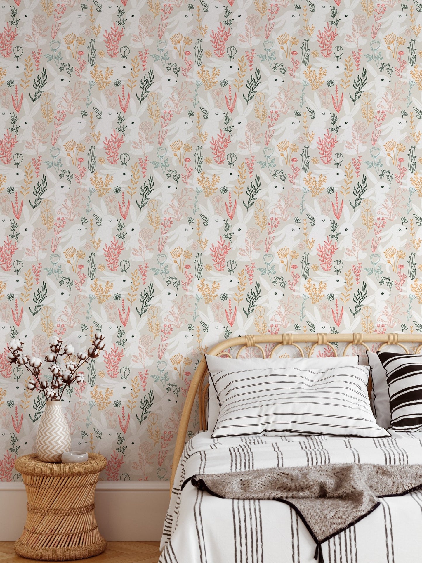 Pastel rabbit and grass wallpaper in a bedroom with wooden side table.