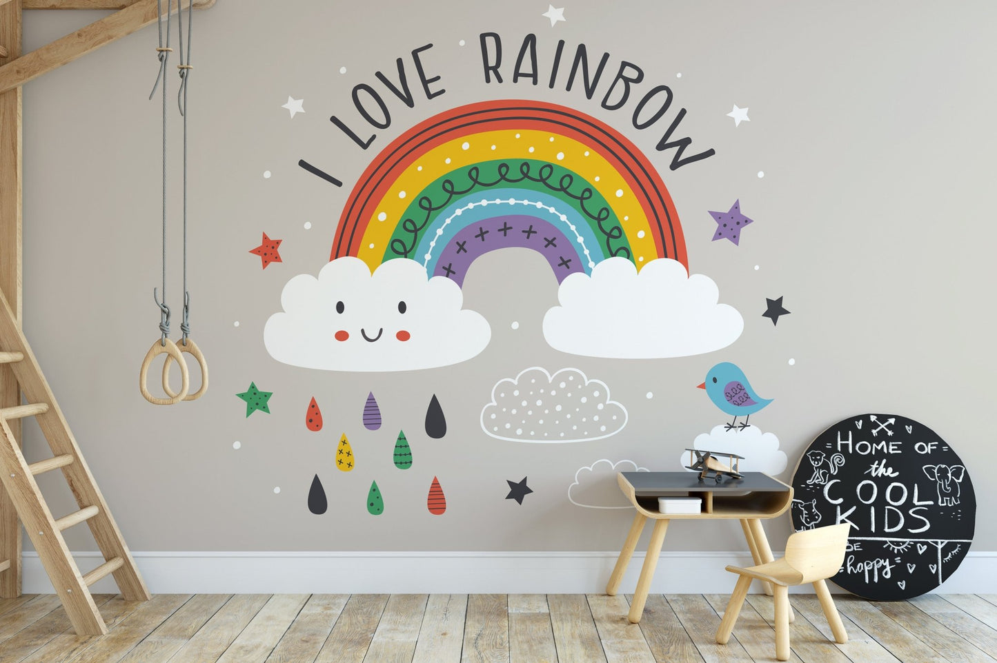 Children's study desk positioned against a beige wall mural with rainbow and bird motifs.