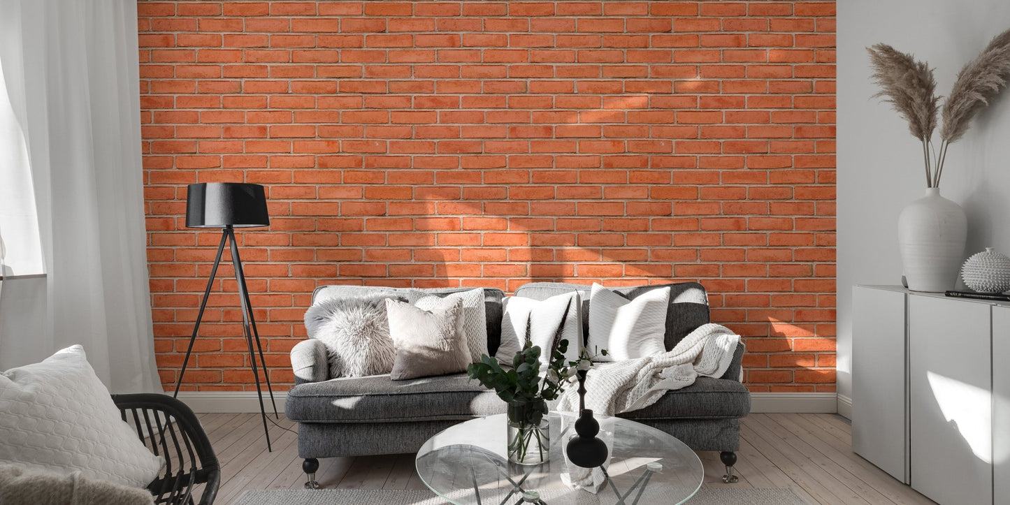 Red brick wallpaper in a bright living area with a grey sofa and black lamp.