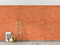 Rustic red brick wallpaper behind a gold towel rack and grey floor.