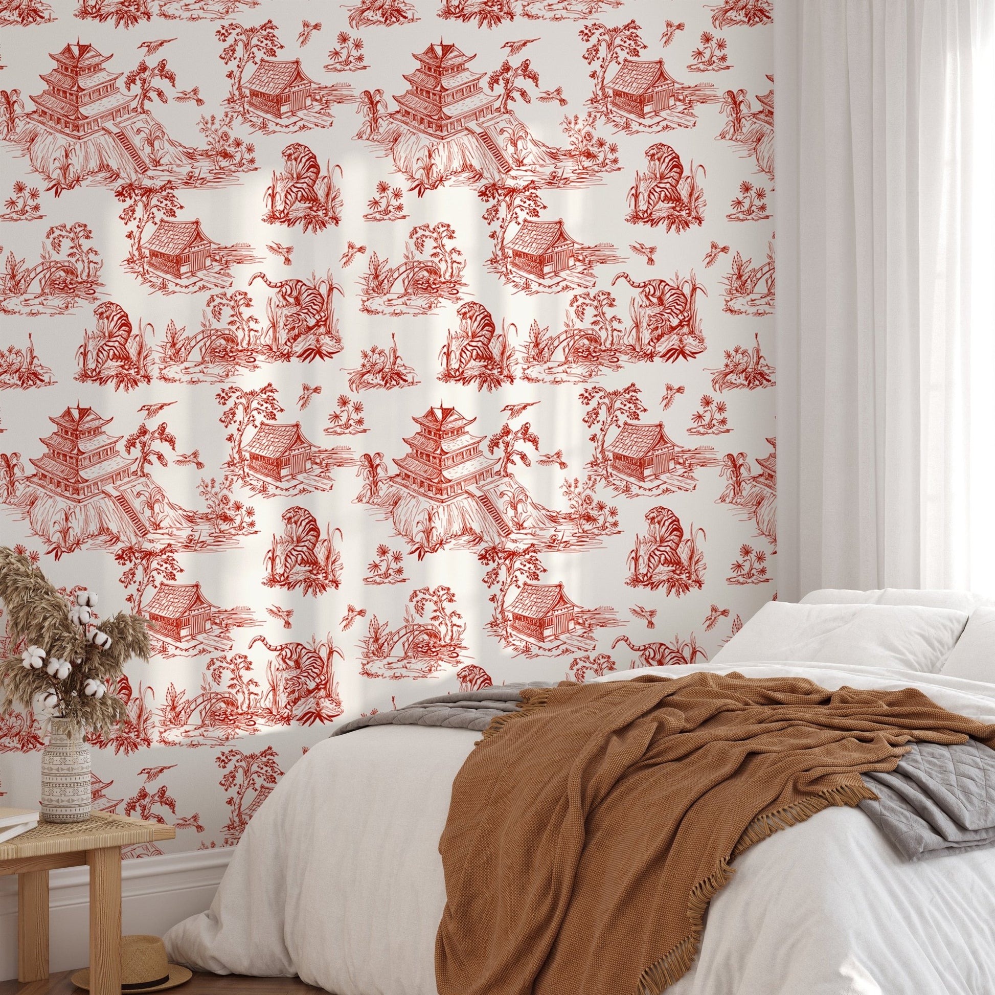 Wallpaper with red pastoral sketches behind a wooden dining table and chairs.