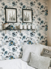 Removable watercolor flower handmade indigo wallpaper behind a bed with framed art.