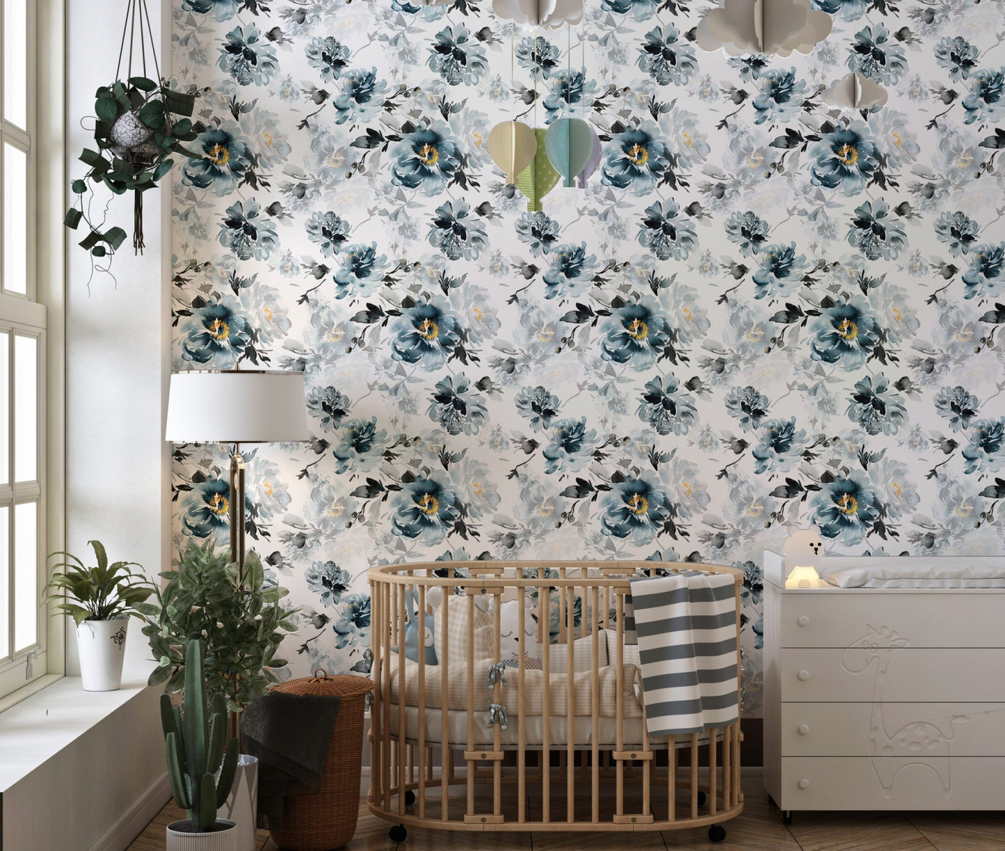 Watercolor flower wallpaper in a nursery with a wooden crib and white dresser.