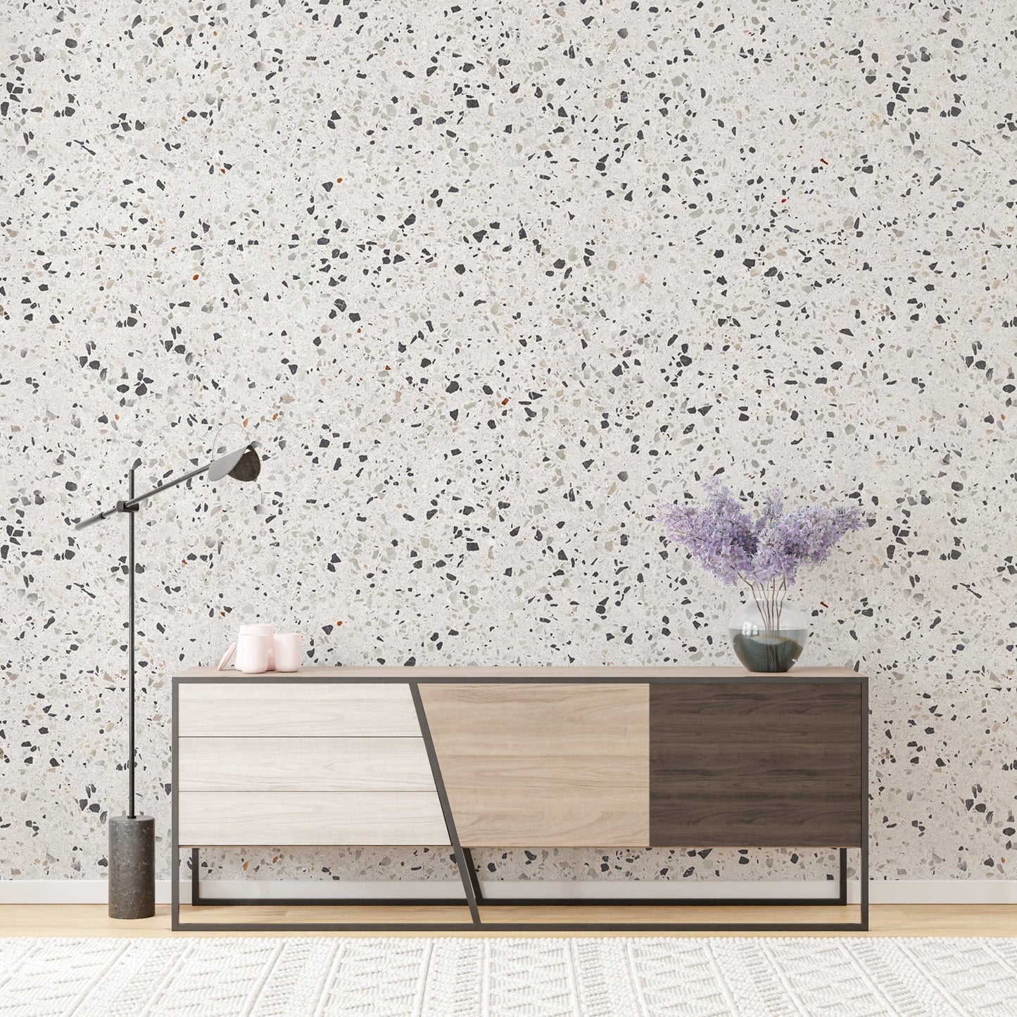 White terrazzo wallpaper behind a modern sideboard with purple flowers.