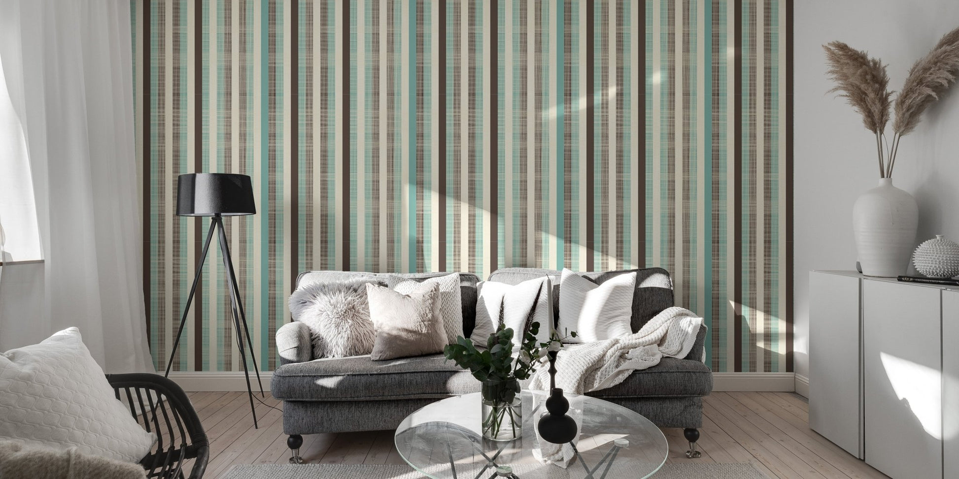 Modern living area featuring striped wallpaper with grey sofa and black lamp.