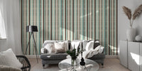 Modern living area featuring striped wallpaper with grey sofa and black lamp.