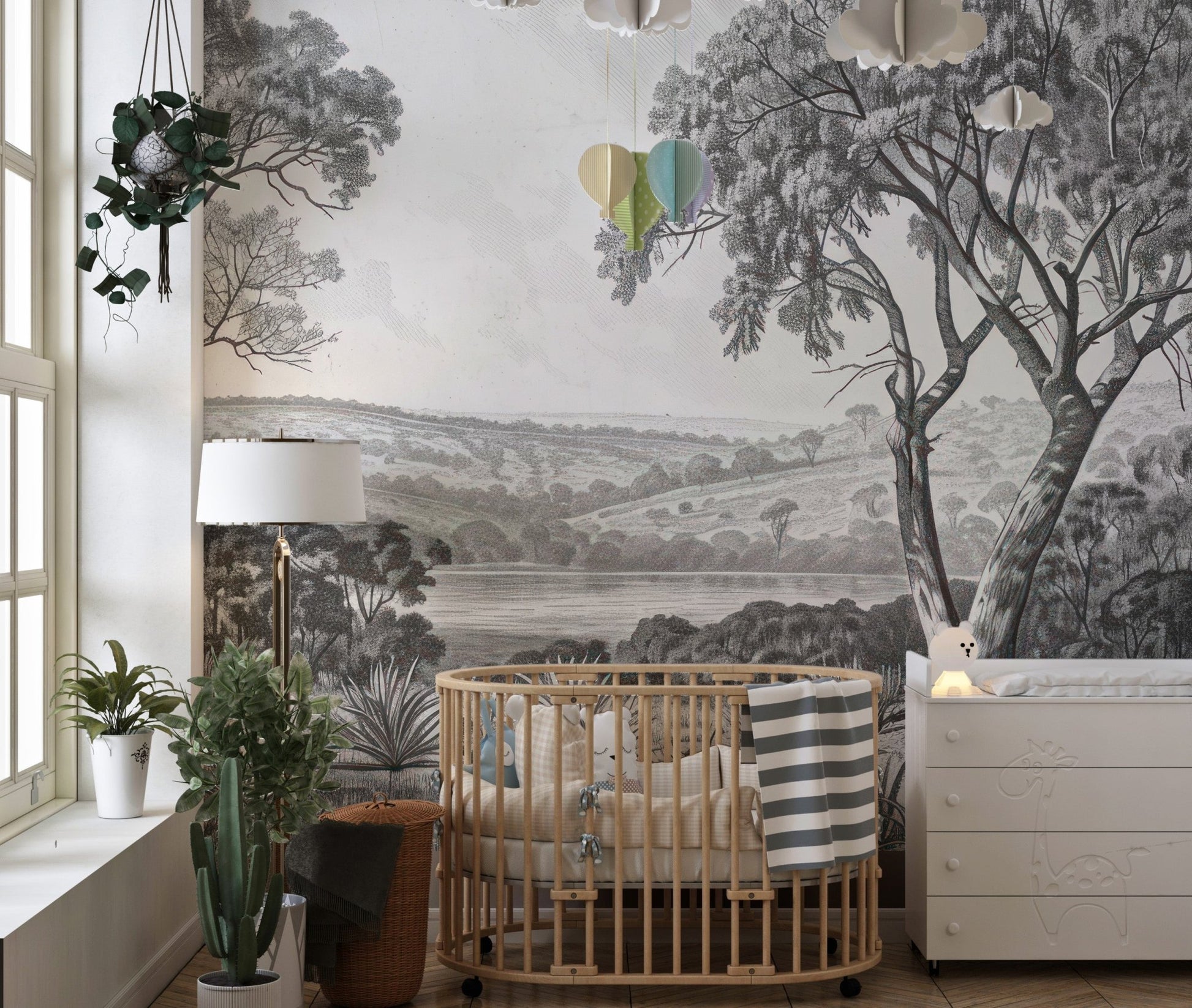 Vintage river valley wall mural installed in a nursery with a wooden crib.