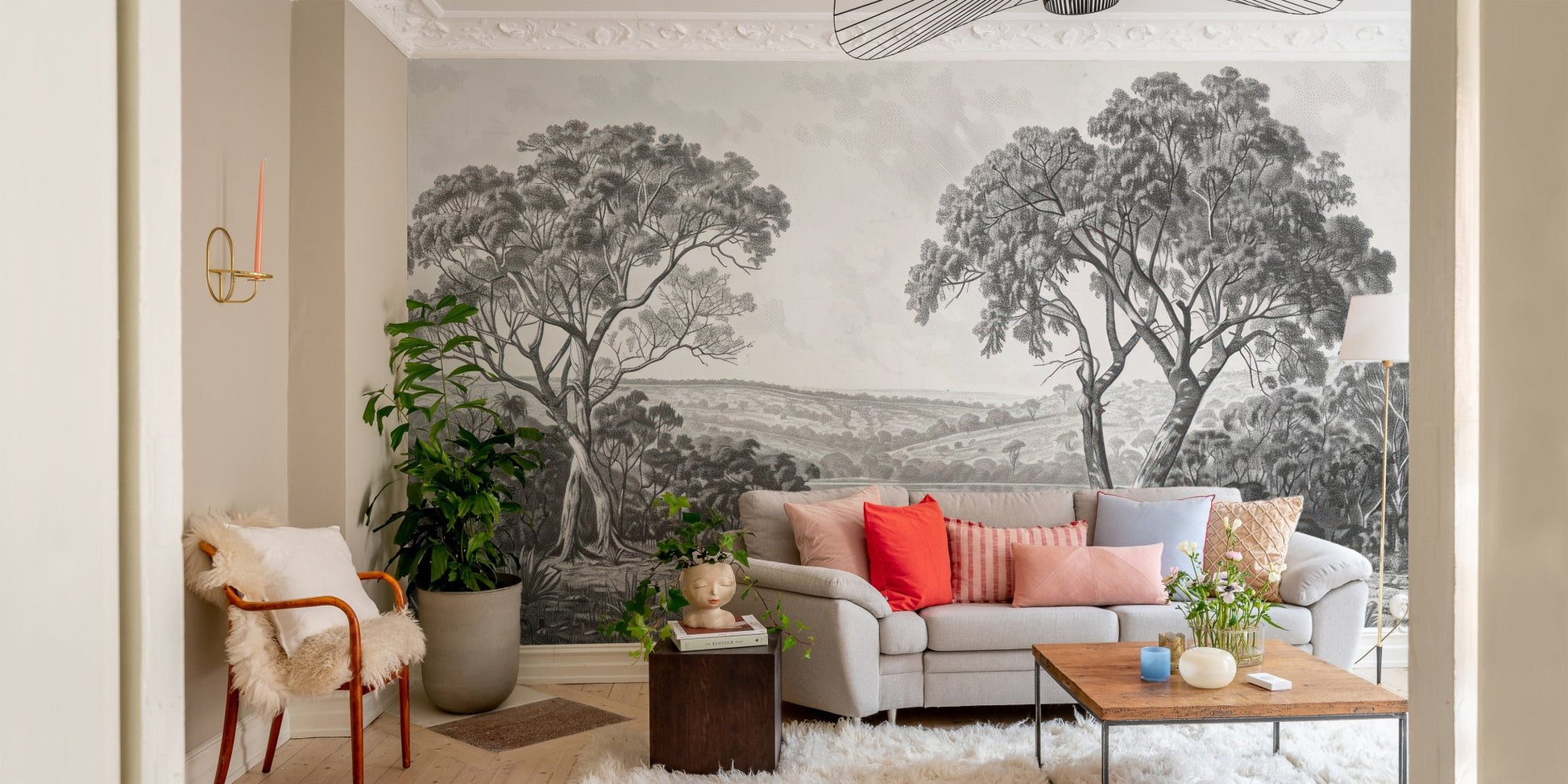Tree and river wall mural in a small seating area with indoor plants.