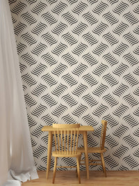 Grey and white geometric wallpaper behind a small wooden table and chair.