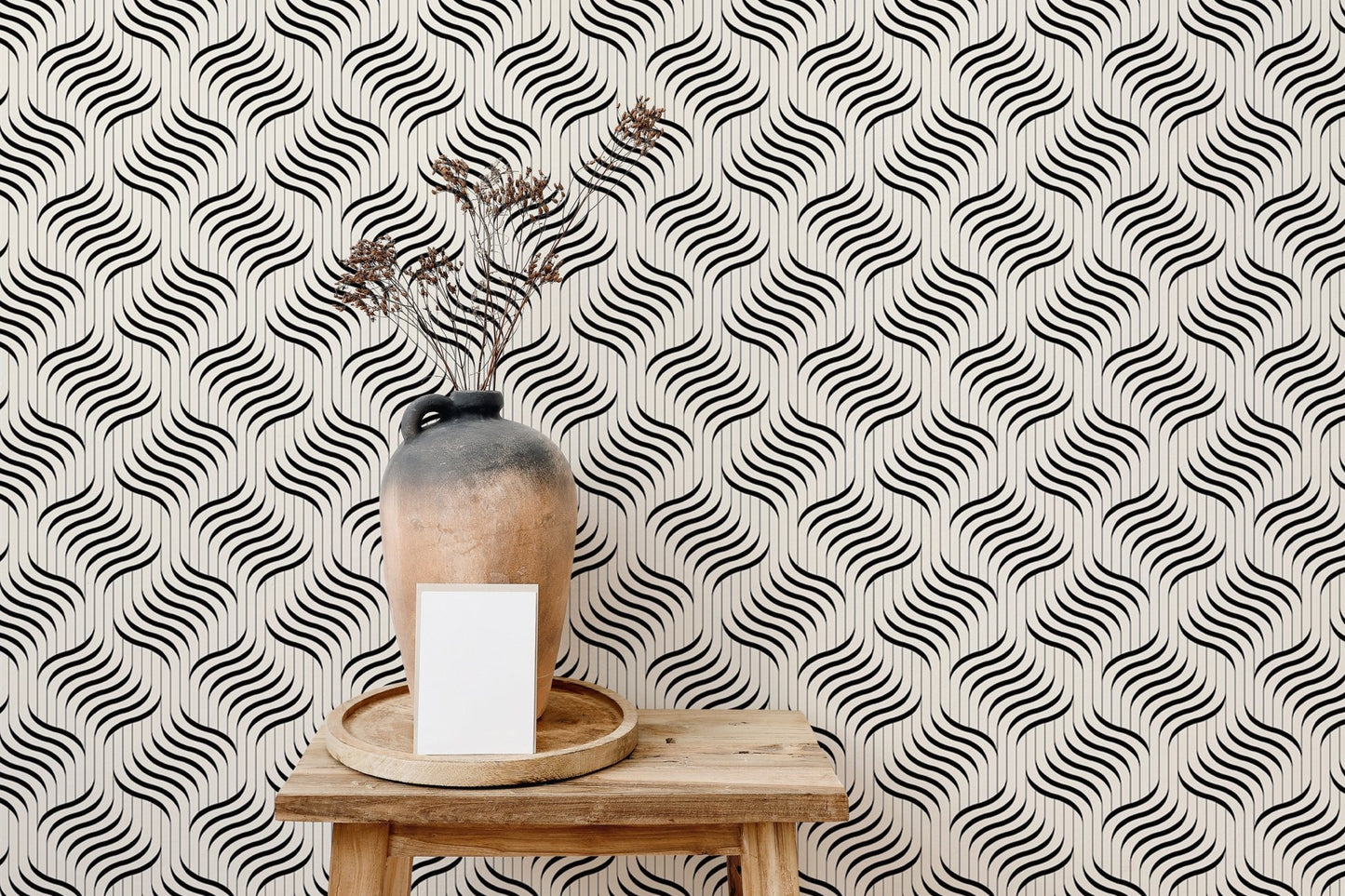 Monochrome ripple wallpaper behind a ceramic vase on a wooden stool.