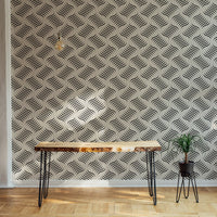 Monochrome wavy pattern wallpaper on a feature wall with indoor plants.