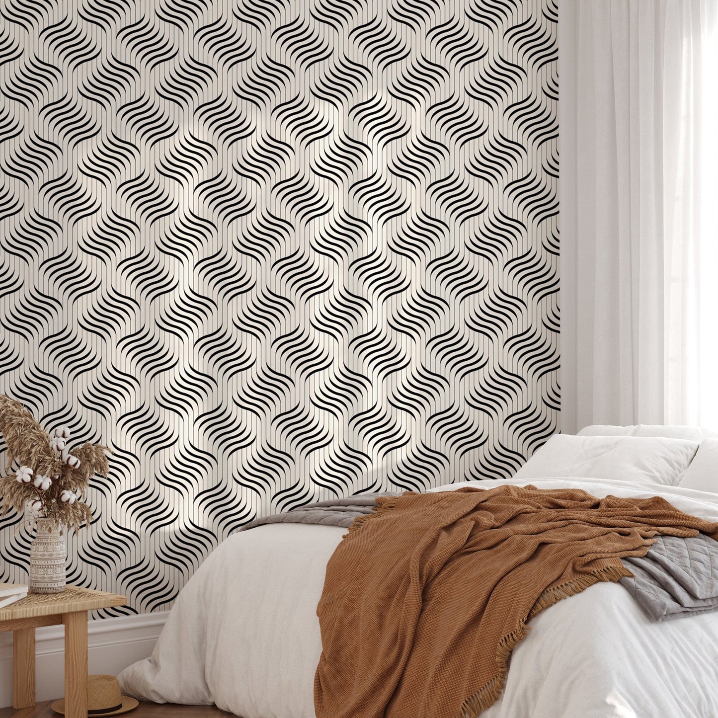 Monochrome ripple wallpaper behind a bed with a brown throw blanket.