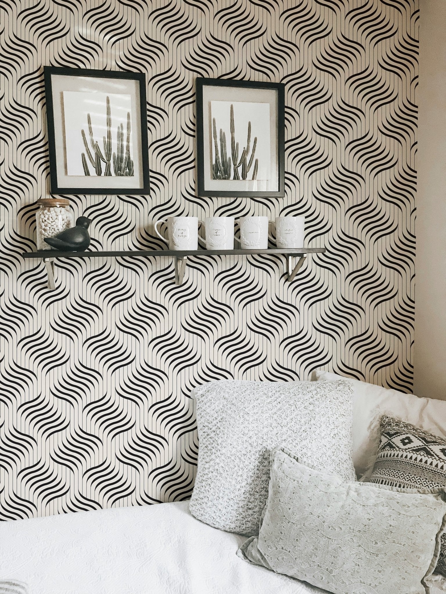 Abstract geometric wallpaper in a bright room with a shelf and framed art.