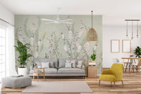 Modern living room featuring green floral wall mural behind a grey fabric sofa.