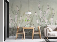 Dining area with wooden table and chairs against green orchid wall mural.