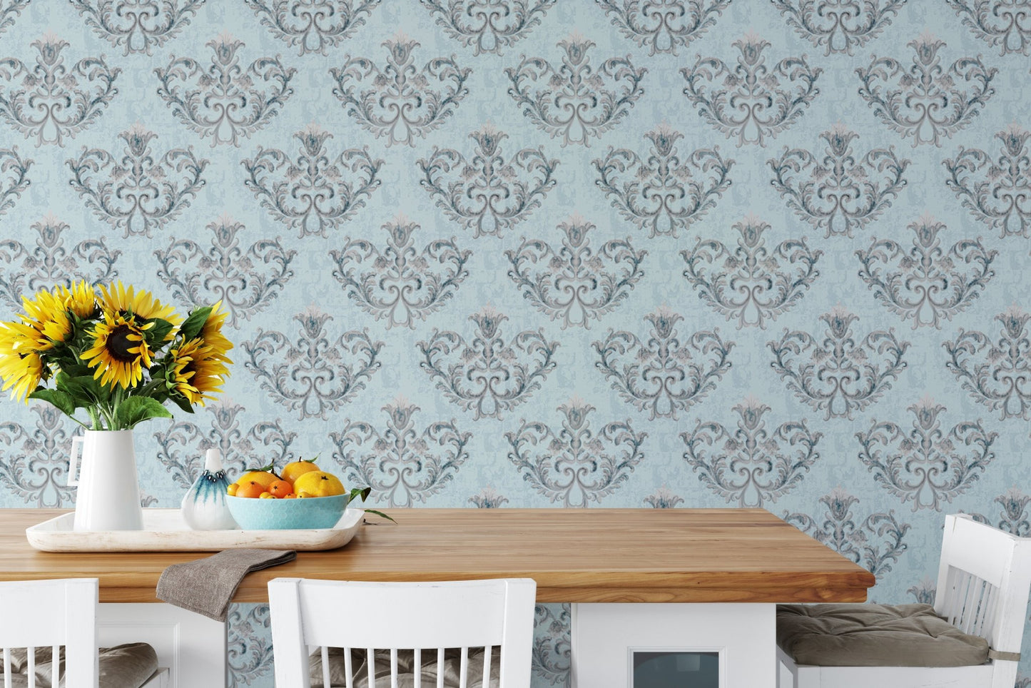 Grey floral wallpaper behind a dining table with yellow flowers in a vase.