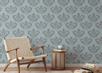 Patterned grey floral wallpaper in a reading area with a wooden armchair.