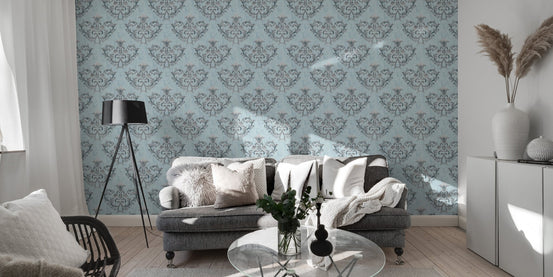 Blue repeat pattern wallpaper in a living space with a grey rug and glass table.