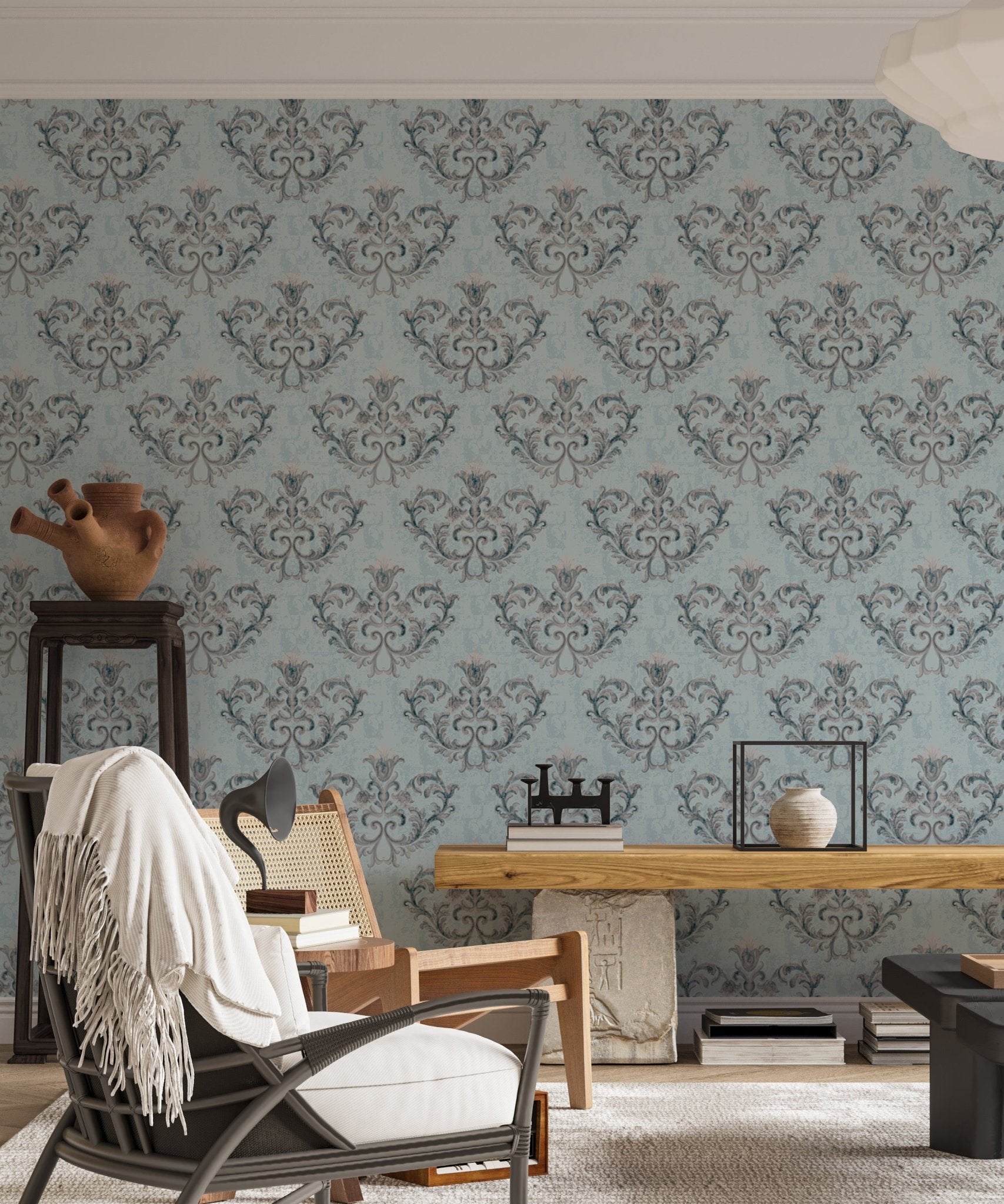 Ornate damask wallpaper in a living area with a black chair and wooden desk.