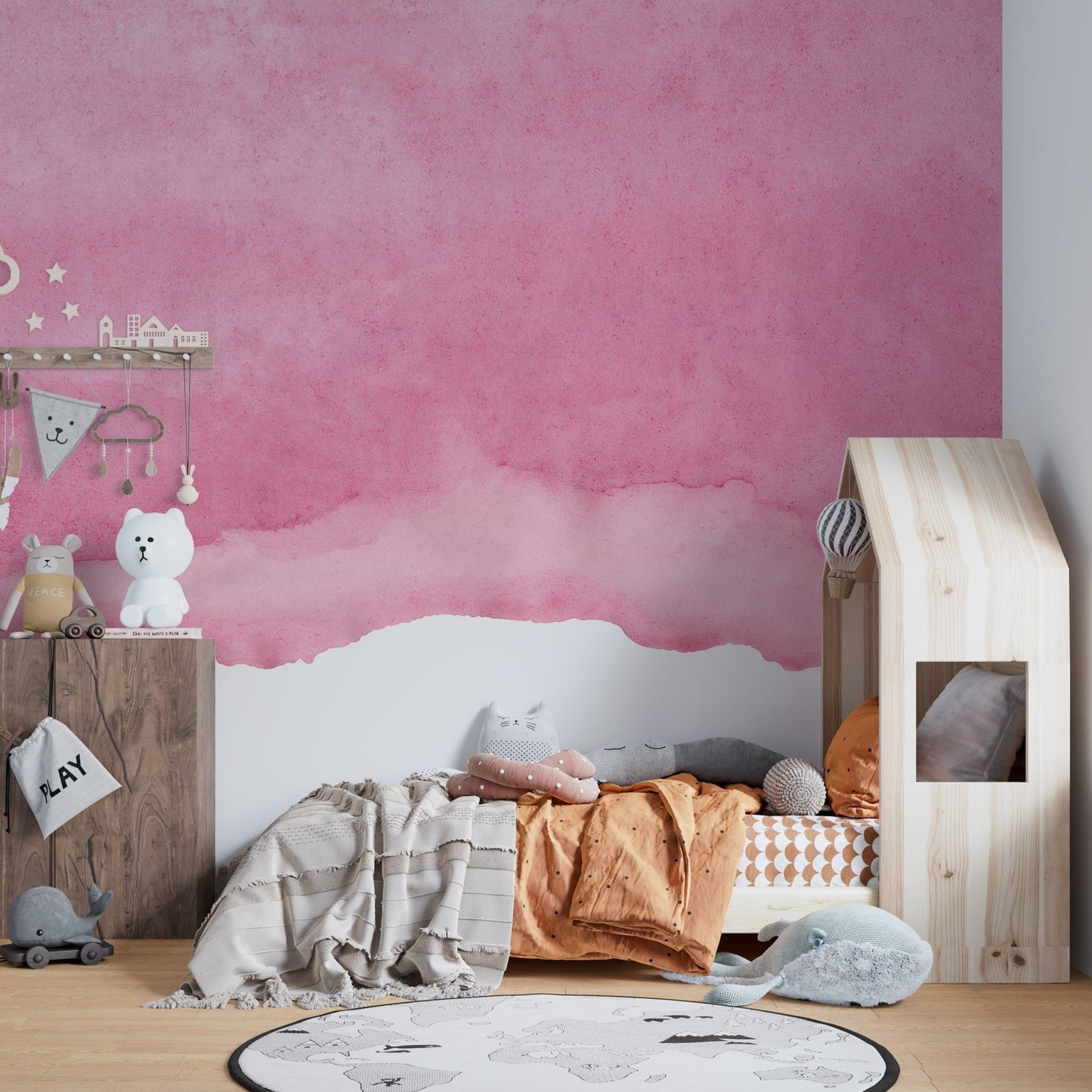Abstract pink wash wall mural in a child's bedroom with a house-shaped bed.