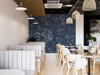Floral wall mural in a cafe dining area with white booths and wooden tables.