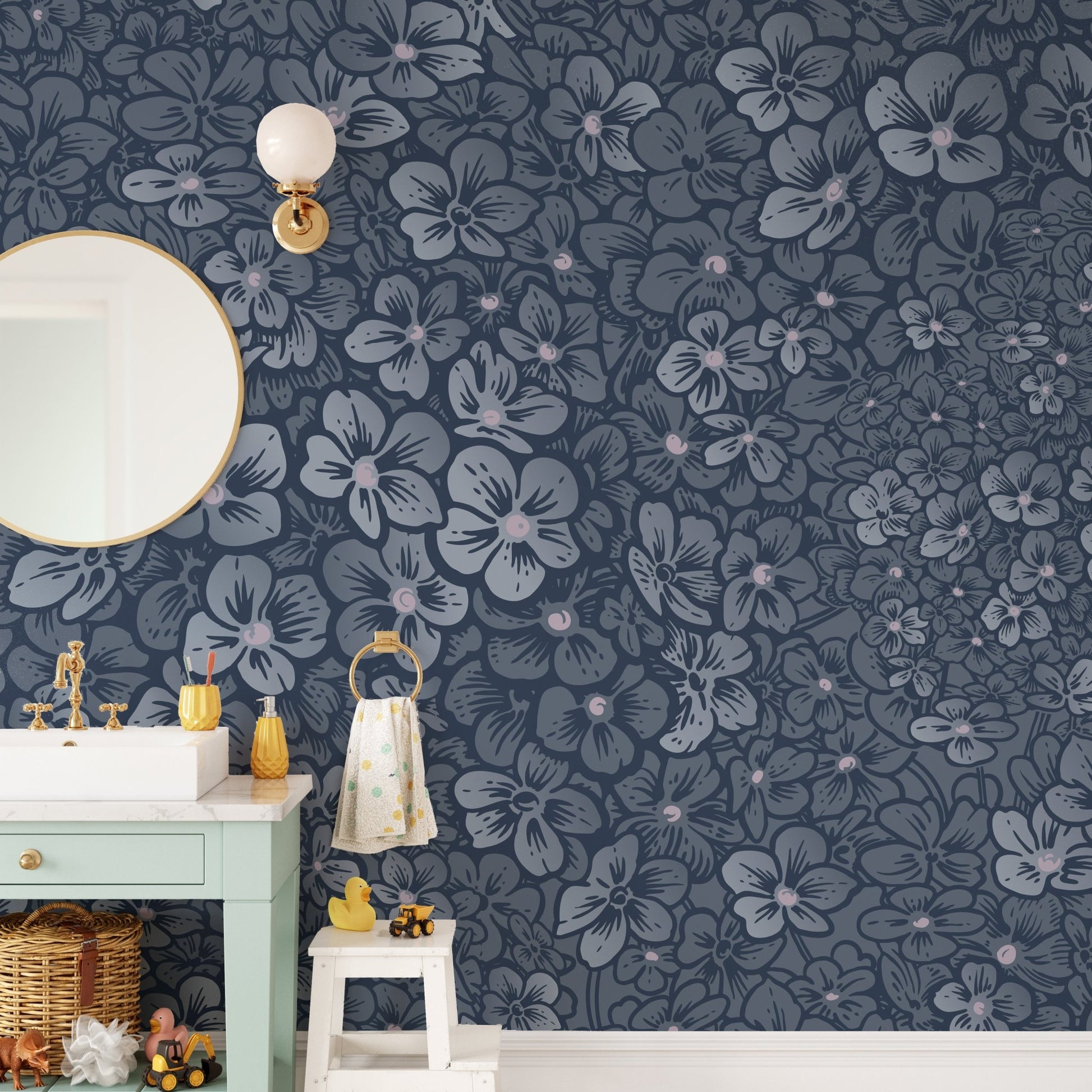 Floral wall mural in a bathroom next to a mint green vanity and round mirror.