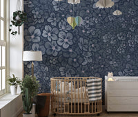 Navy floral wall mural in a nursery with a wooden crib and neutral decor.