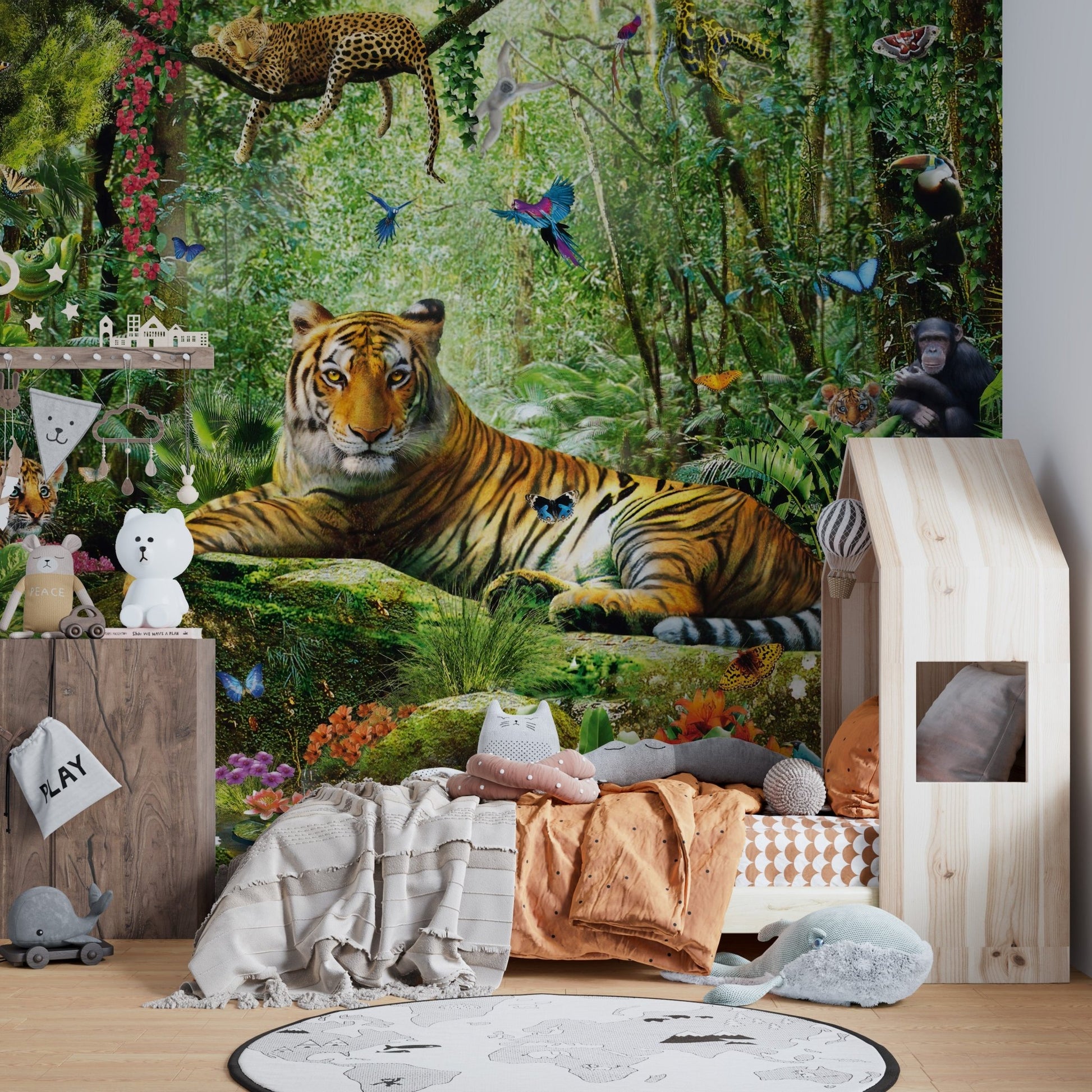 Realistic safari wall mural in a child's bedroom with a floor bed and pillows.