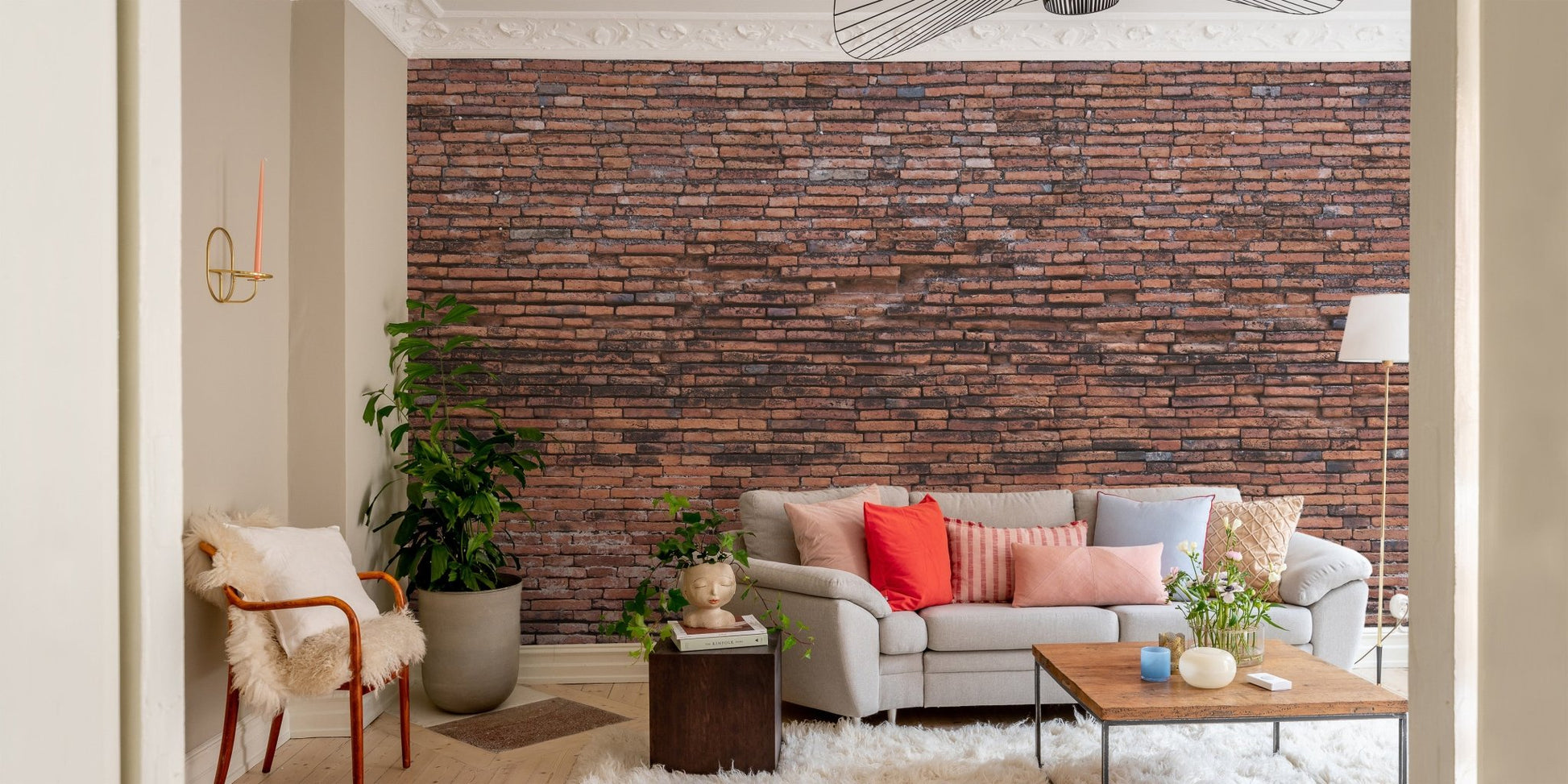 Industrial style brick wall mural behind a grey couch and wooden coffee table.