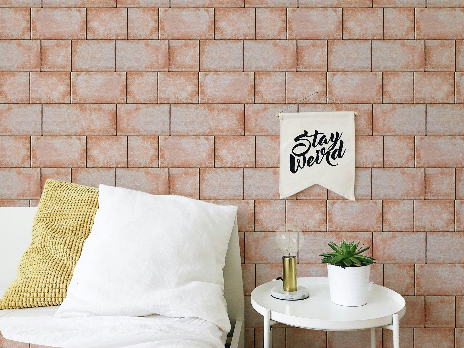 Textured sandstone wallpaper behind a white unit and plants in bedroom.
