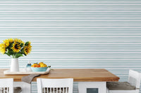 Modern dining space with horizontal striped wallpaper and wooden table.