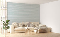 Minimalist living room featuring light green striped wallpaper behind a white sofa.