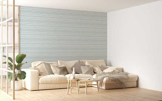 Minimalist living room featuring light green striped wallpaper behind a white sofa.