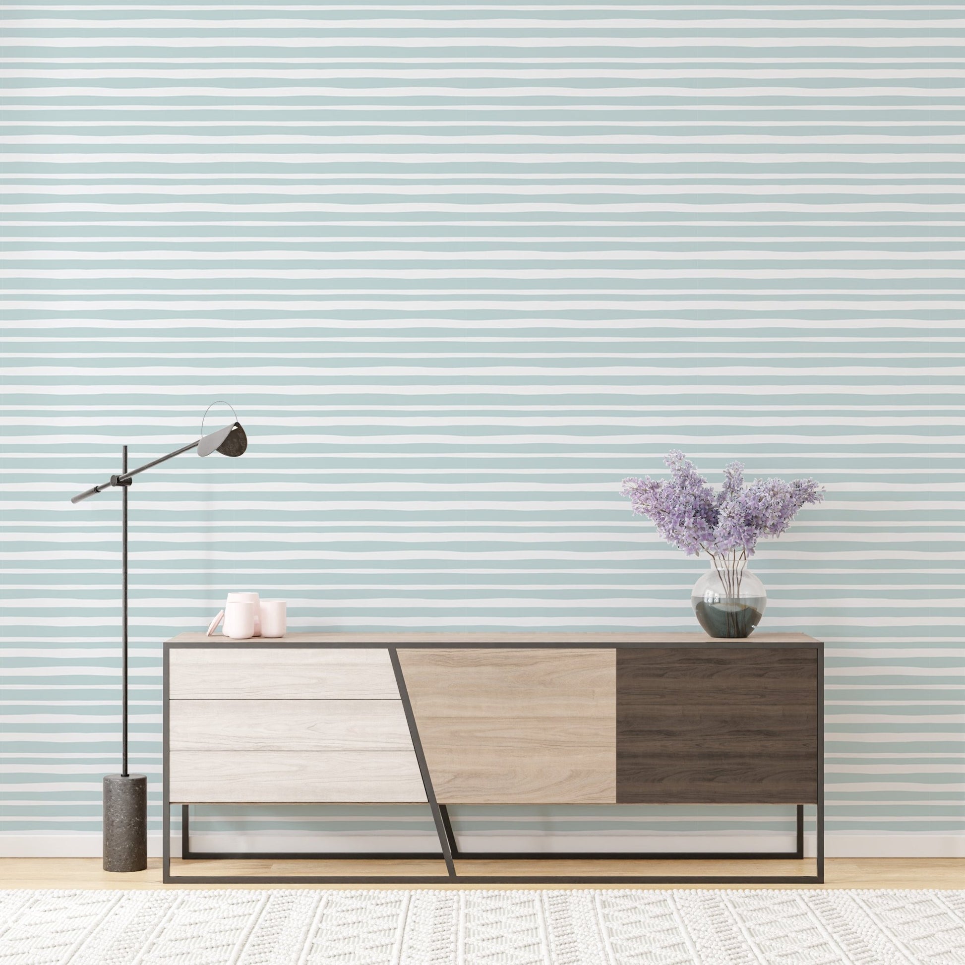 Minimalist sideboard cabinet placed against sea green horizontal striped wallpaper
