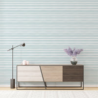 Minimalist sideboard cabinet placed against sea green horizontal striped wallpaper