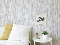 Minimalist bedroom featuring a white and black line wallpaper