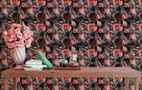 Moody floral wallpaper behind a wooden desk and chair in a home workspace