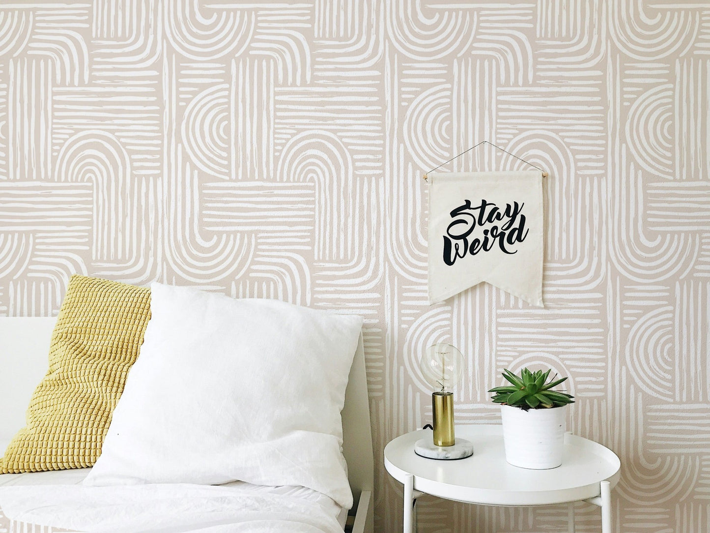 Bedroom wallpaper with cream swell lines behind a white bed and side table.