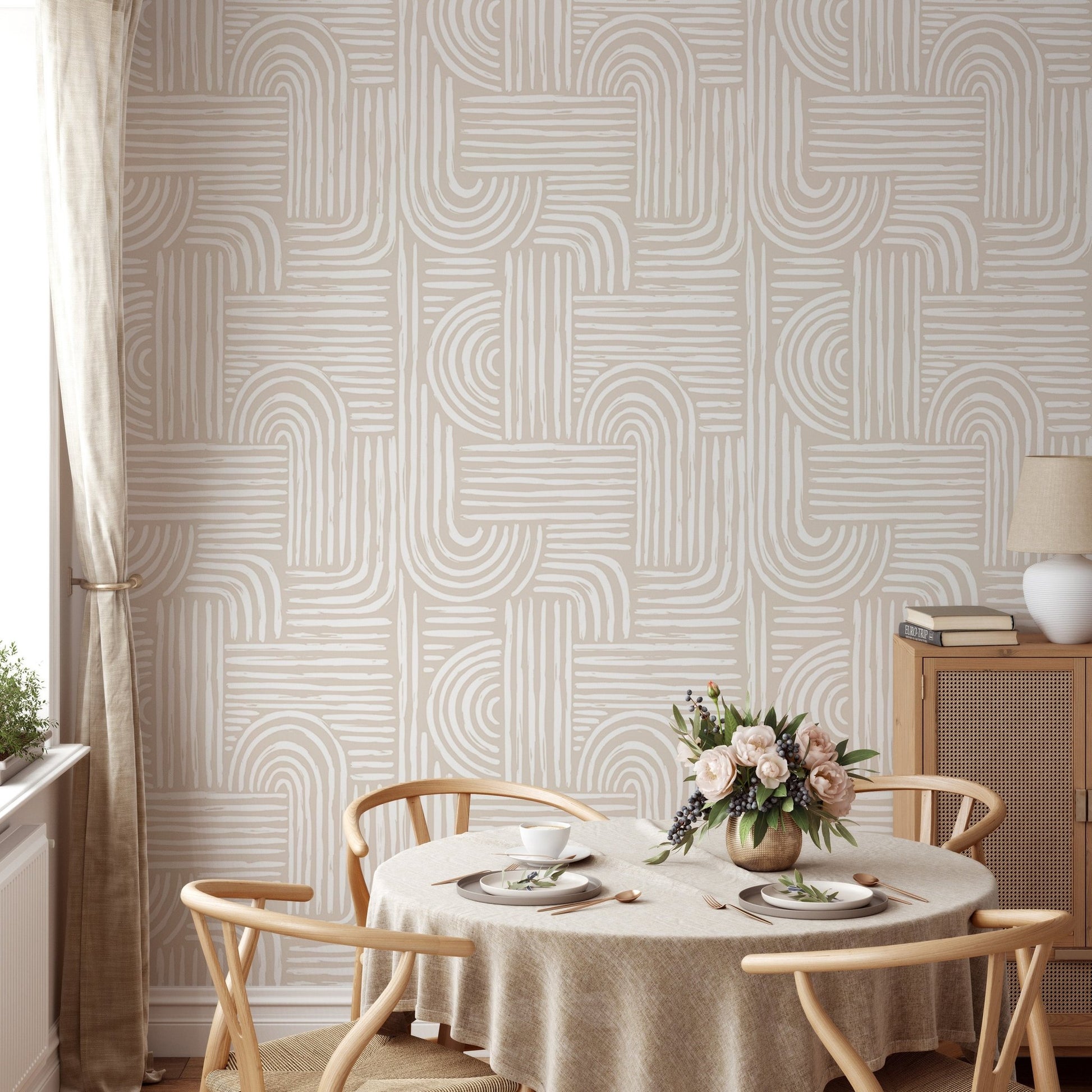 Neutral tone abstract wallpaper in a dining room with a round table and wooden chairs.