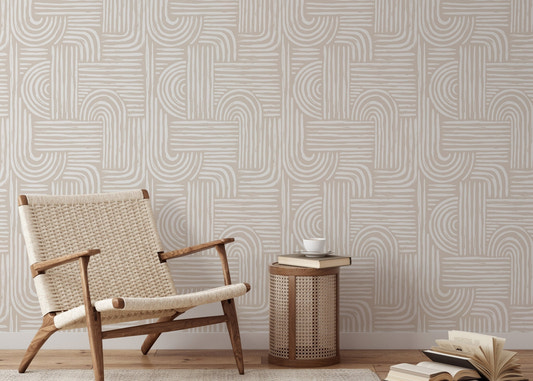 Abstract line wallpaper in a living room with a woven lounge chair and wooden side table.